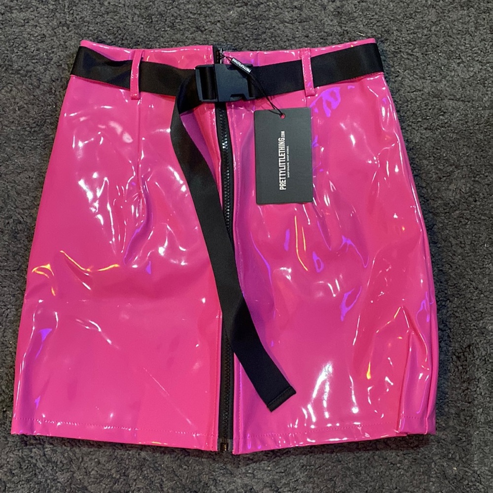 Hot pink latex skirt including belts. Has a black zipper detail.